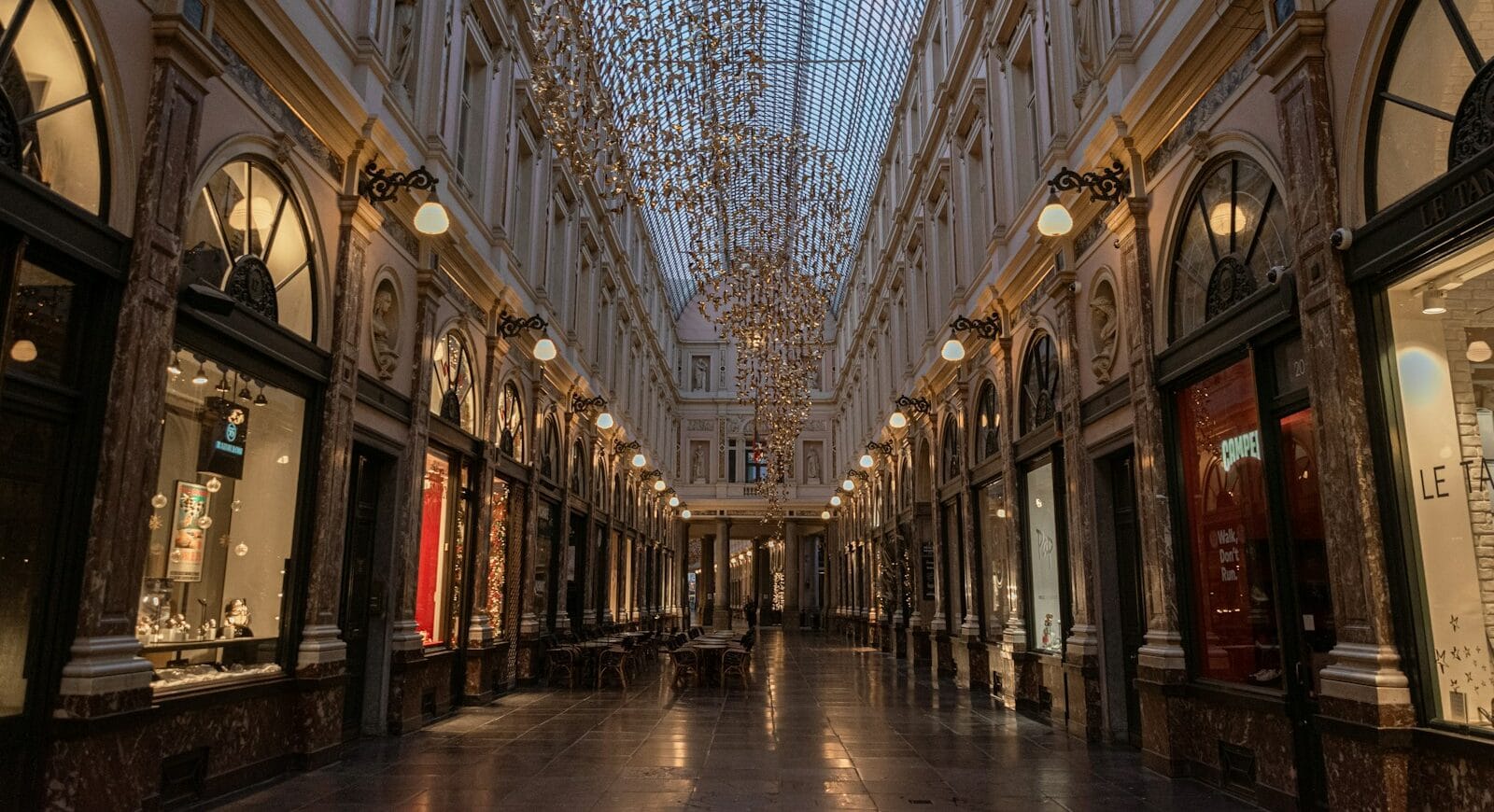 Belgium Travel Guide an empty shopping mall with chandeliers hanging from the ceiling