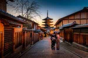 japan travel guide two women in purple and pink kimono standing on street