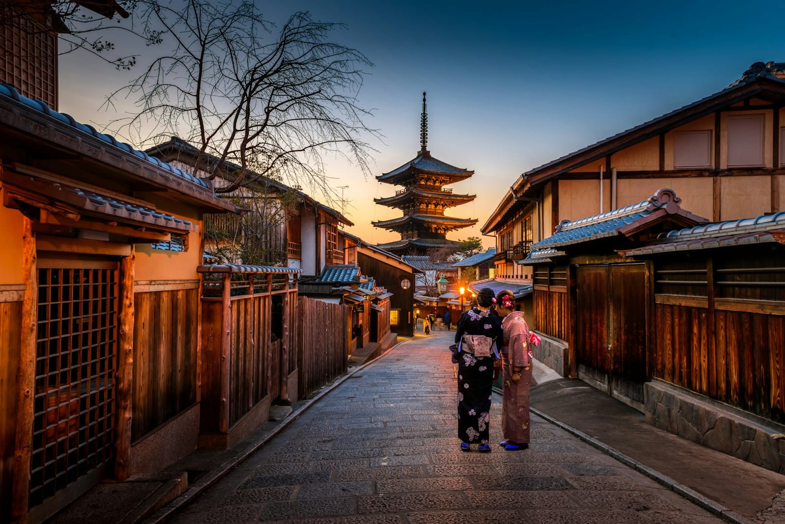 japan travel guide two women in purple and pink kimono standing on street