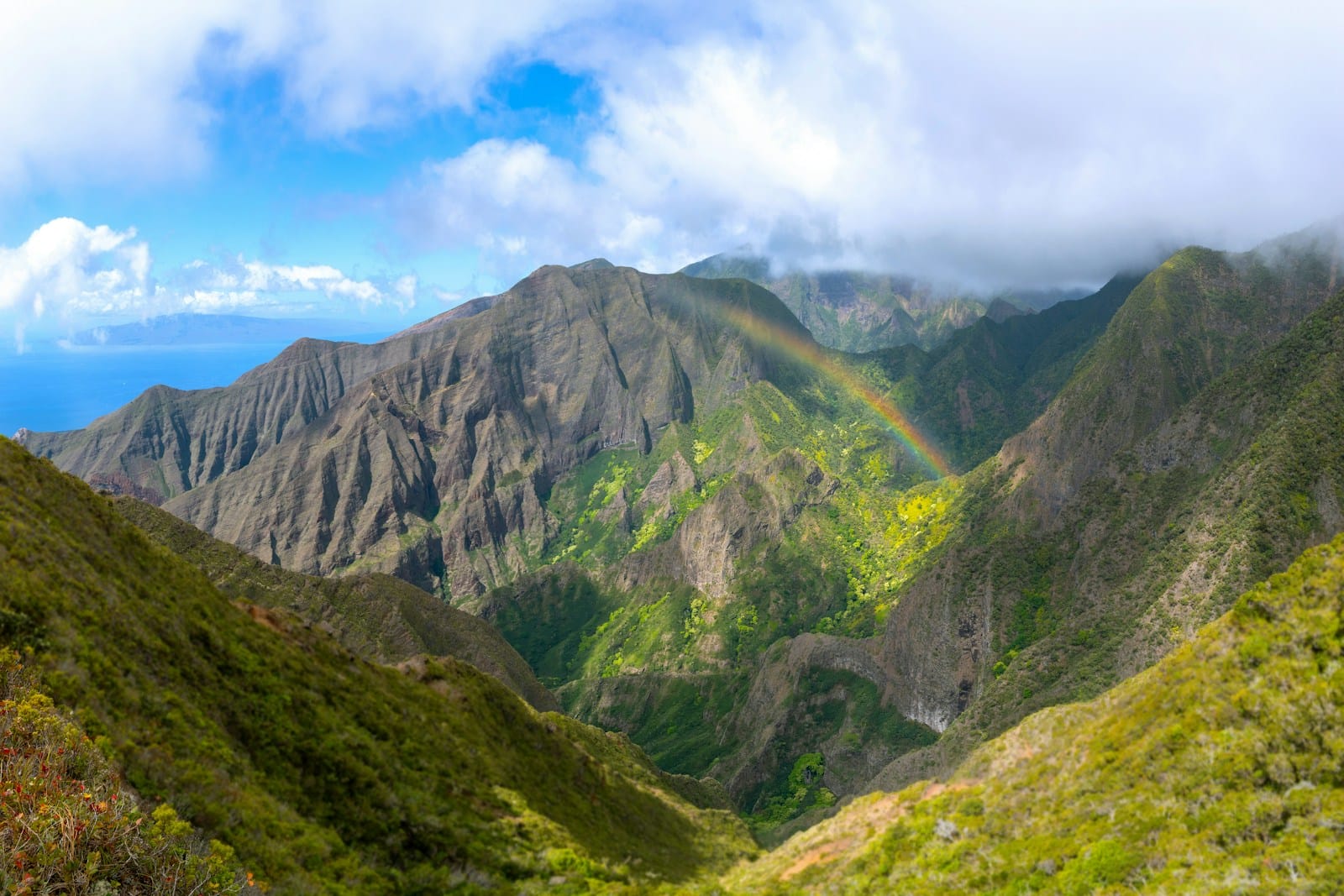 Maui Travel Guide Mountains and a rainbow create a beautiful landscape.