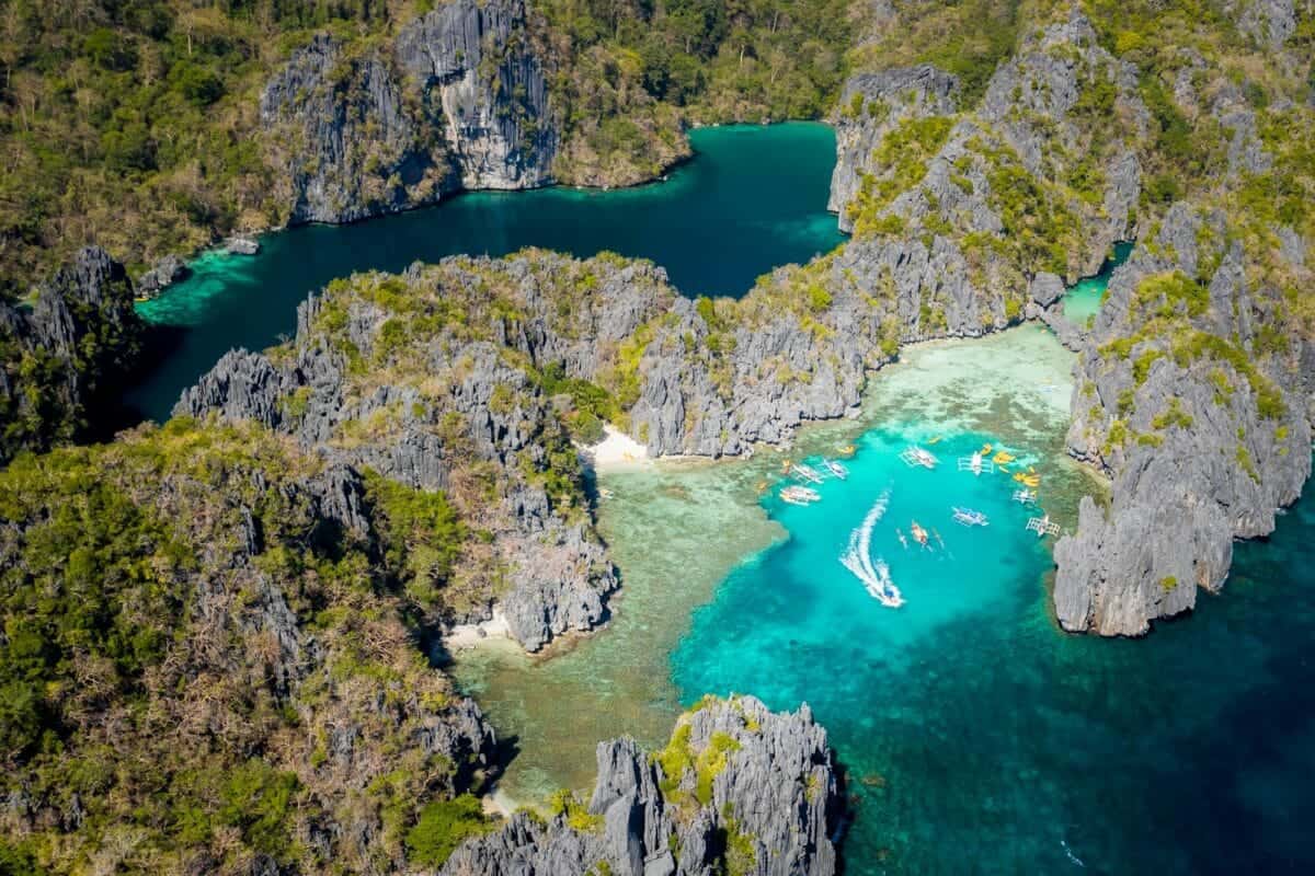 Philippines Beaches Travel Guide aerial view of green lake surrounded by green trees during daytime