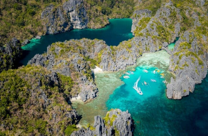 Philippines Beaches Travel Guide aerial view of green lake surrounded by green trees during daytime