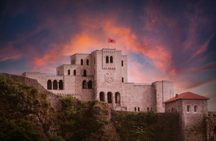Albania Travel Guide A castle on a hill with a sunset in the background