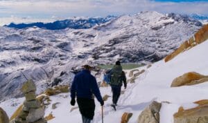 Adventure Travel a couple of people walking up a snow covered slope