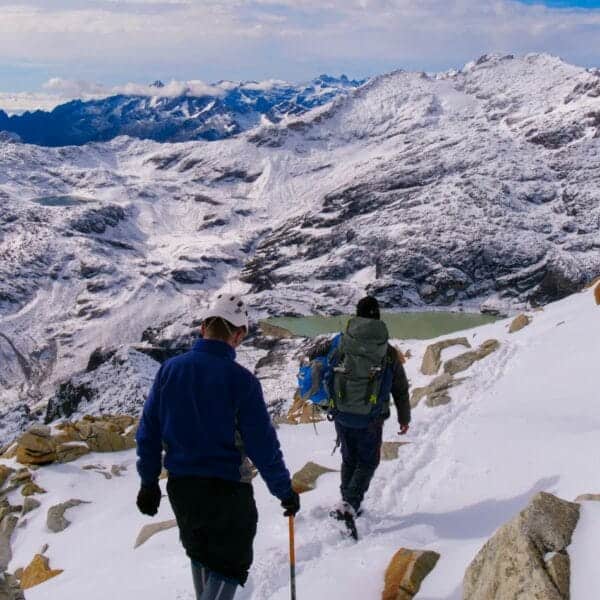 Adventure Travel a couple of people walking up a snow covered slope