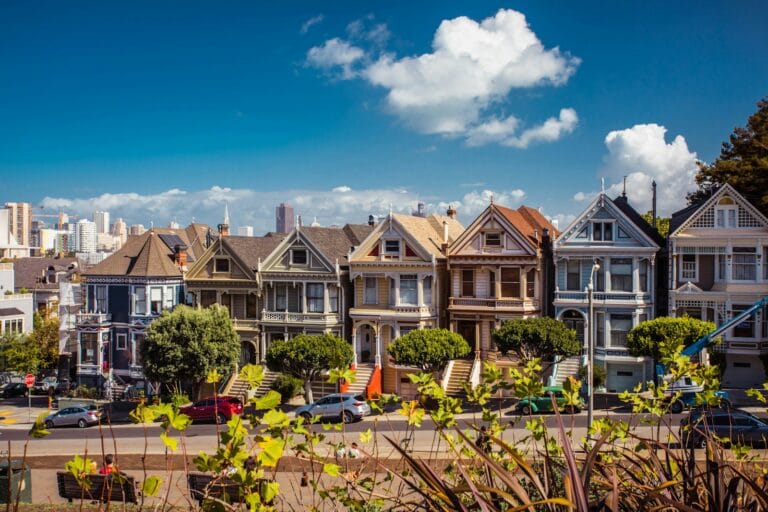 San Francisco Tours white and brown 2-storey houses with vehicles in front during daytime