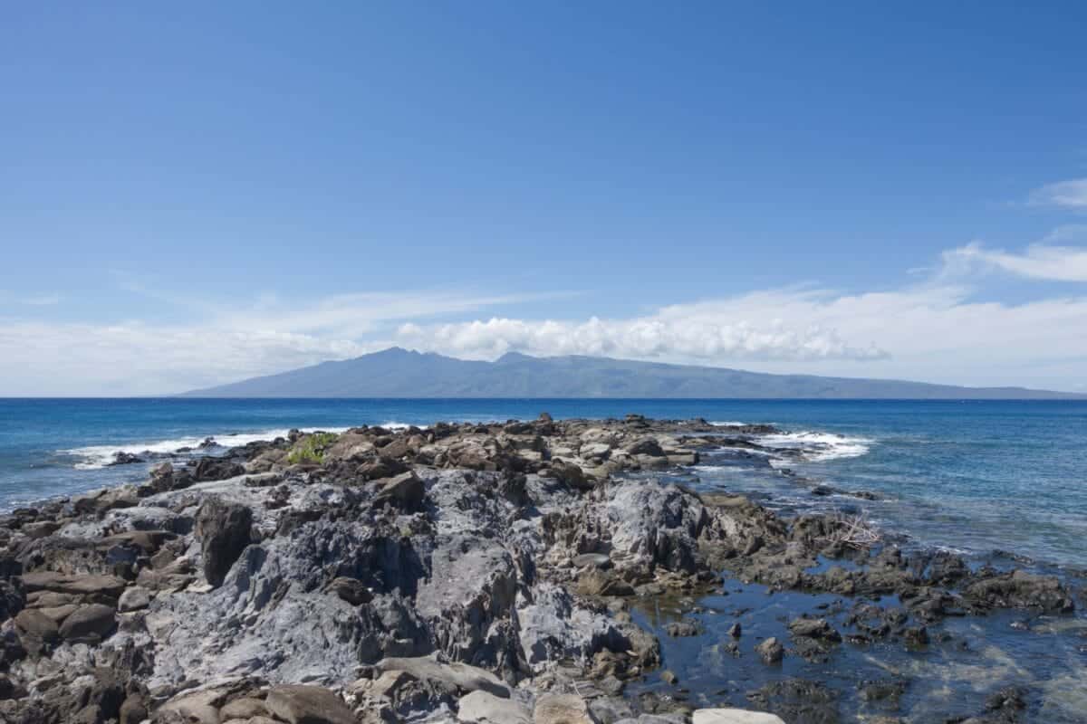 Molokai Tours a rocky beach with a body of water in the background