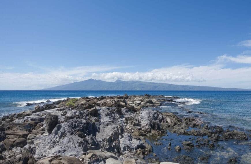 Molokai Tours a rocky beach with a body of water in the background