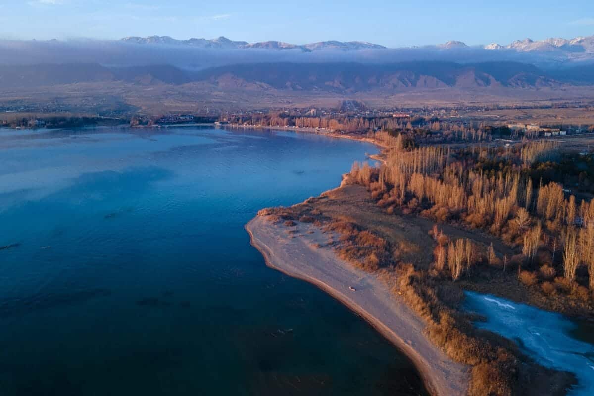 Kyrgyzstan Travel Guide aerial view of body of water near trees during daytime