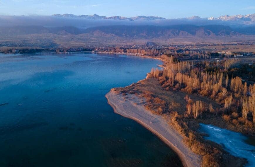 Kyrgyzstan Travel Guide aerial view of body of water near trees during daytime