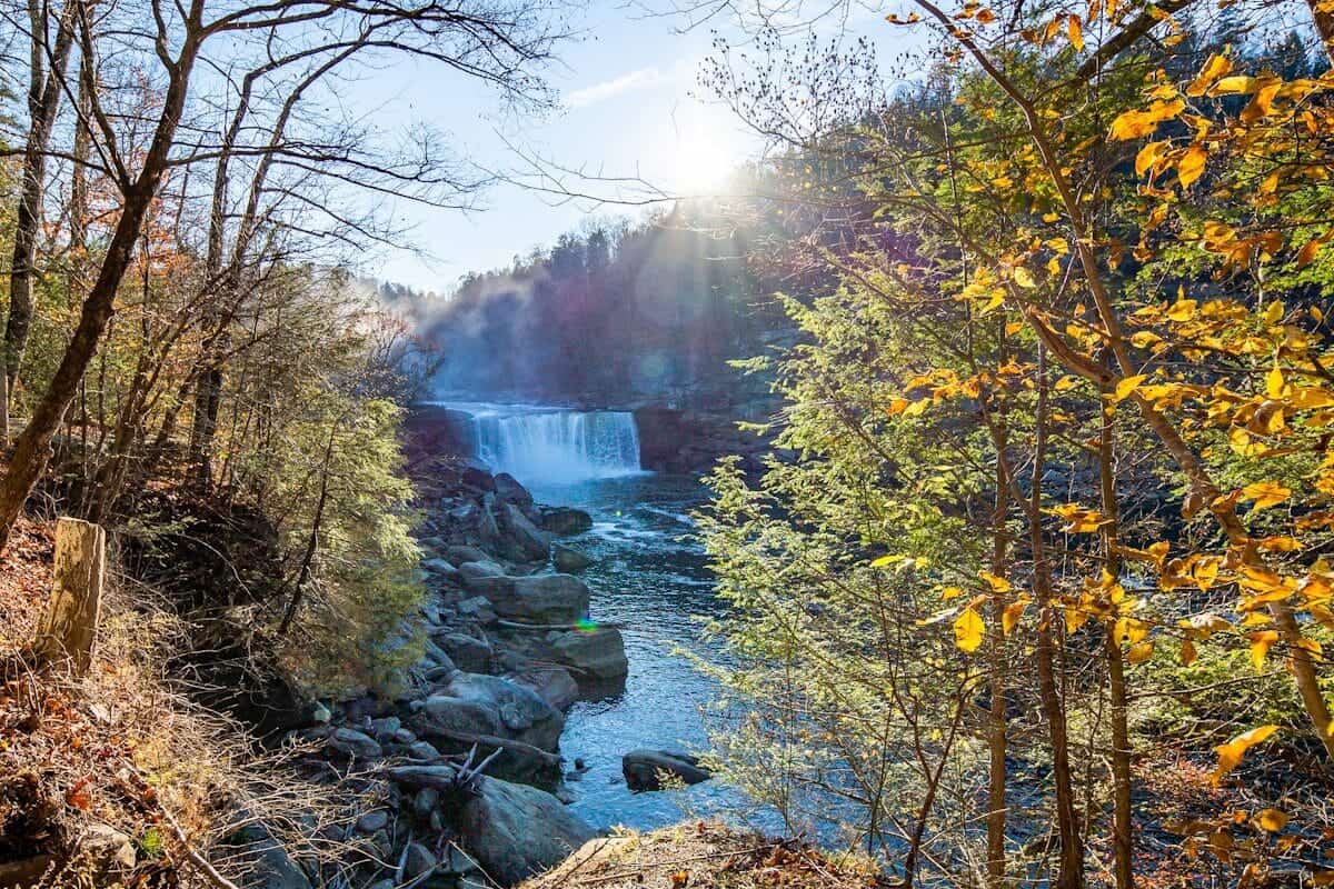 Kentucky Travel Guide the sun is shining over a waterfall in the woods