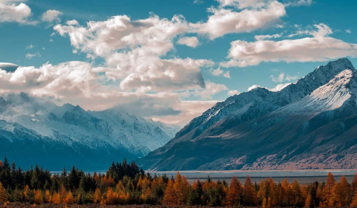 New Zealand Travel Guide snow-capped mountain in the horizon with cumulus clouds