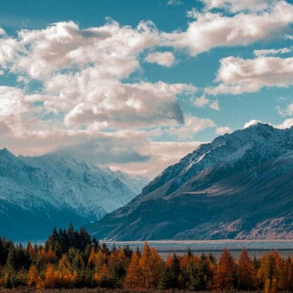 New Zealand Travel Guide snow-capped mountain in the horizon with cumulus clouds