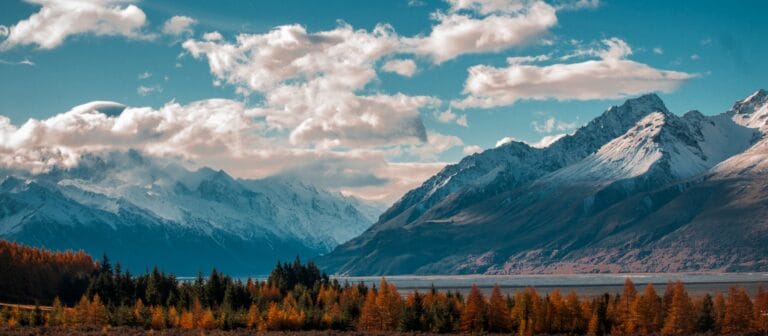 New Zealand Travel Guide snow-capped mountain in the horizon with cumulus clouds