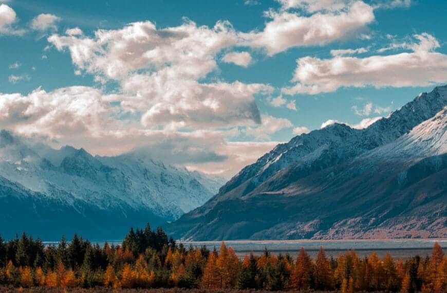 New Zealand Travel Guide snow-capped mountain in the horizon with cumulus clouds