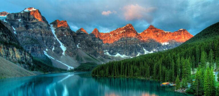 alberta travel guide calm body of water and mountains wallpaper