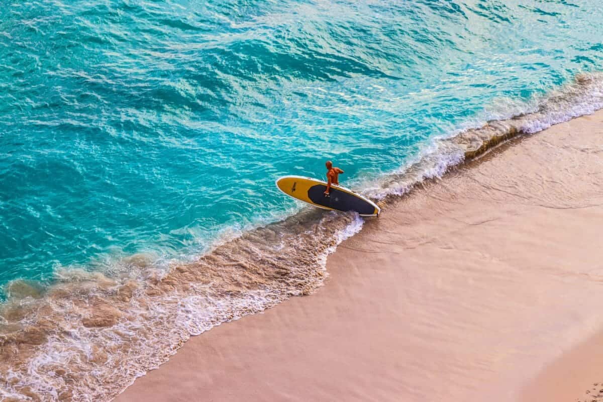 Hawaii Travel Guide man in yellow surfing board on sea waves during daytime