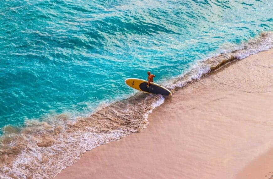 Hawaii Travel Guide man in yellow surfing board on sea waves during daytime