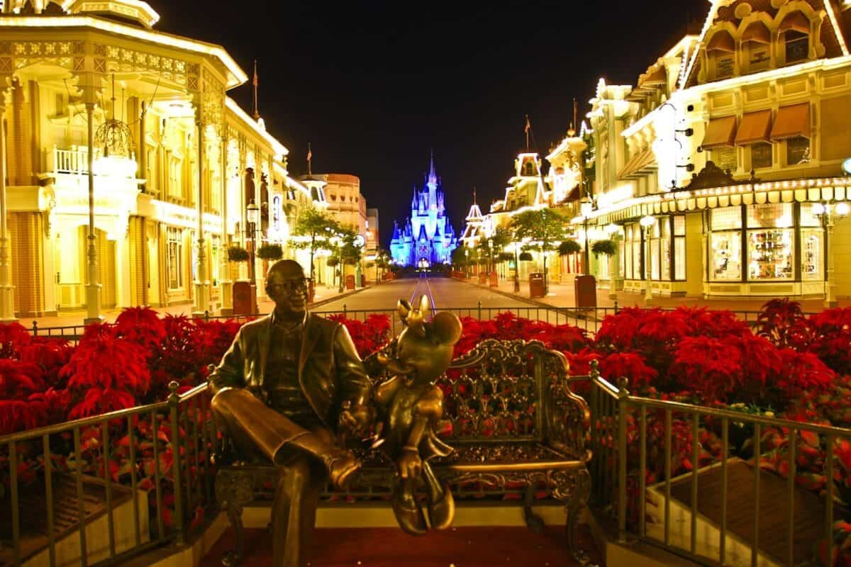 Orlando Travel Guide man in black jacket sitting on brown wooden bench during night time