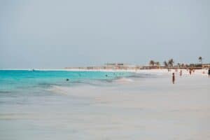 Cape Verde Travel Guide a group of people standing on top of a sandy beach