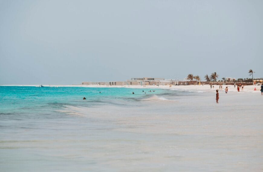 Cape Verde Travel Guide a group of people standing on top of a sandy beach
