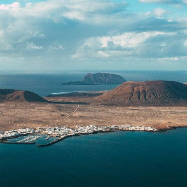 Canary Islands Travel Guide brown mountain near body of water under blue sky during daytime