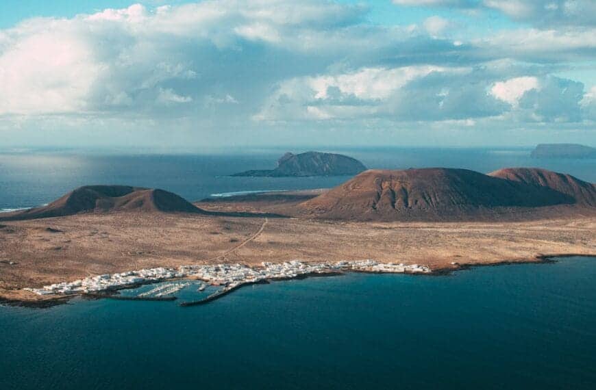 Canary Islands Travel Guide brown mountain near body of water under blue sky during daytime