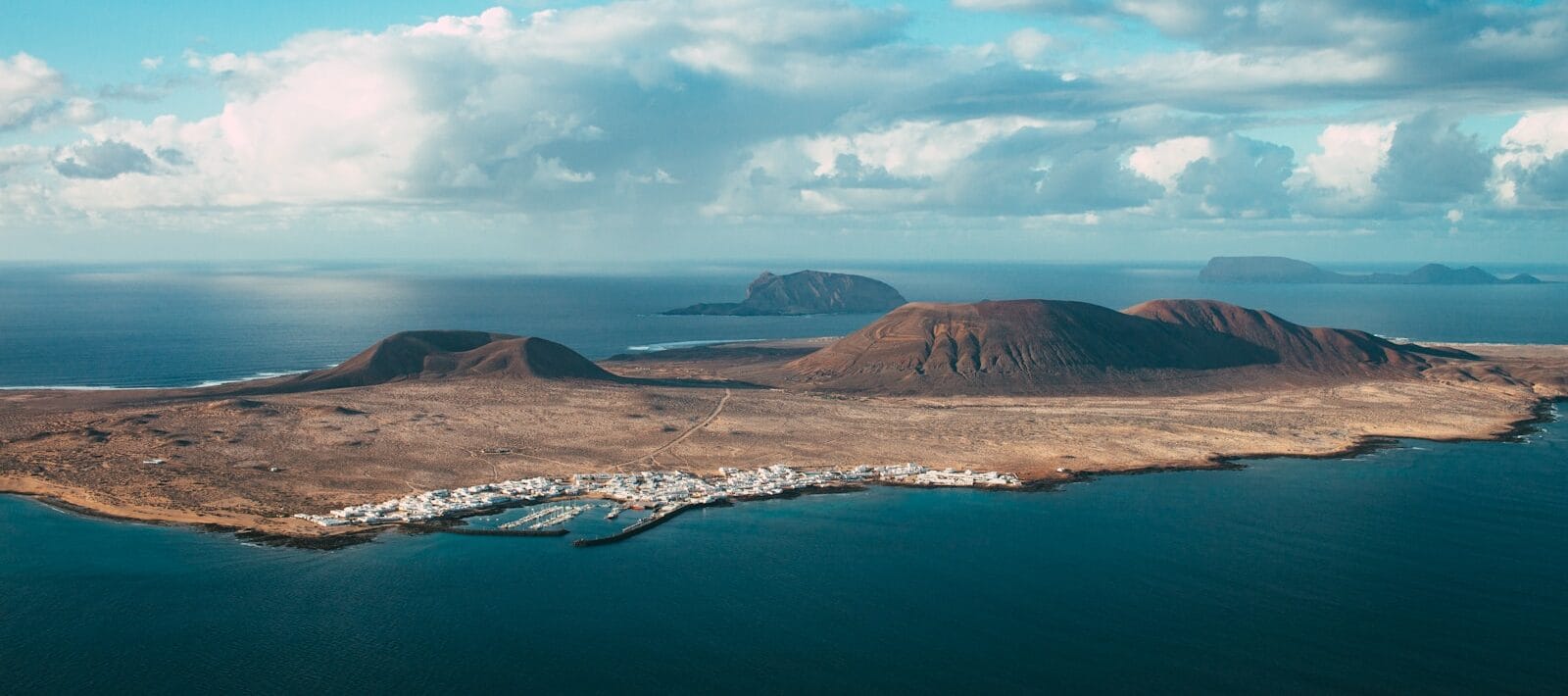 Canary Islands Travel Guide brown mountain near body of water under blue sky during daytime