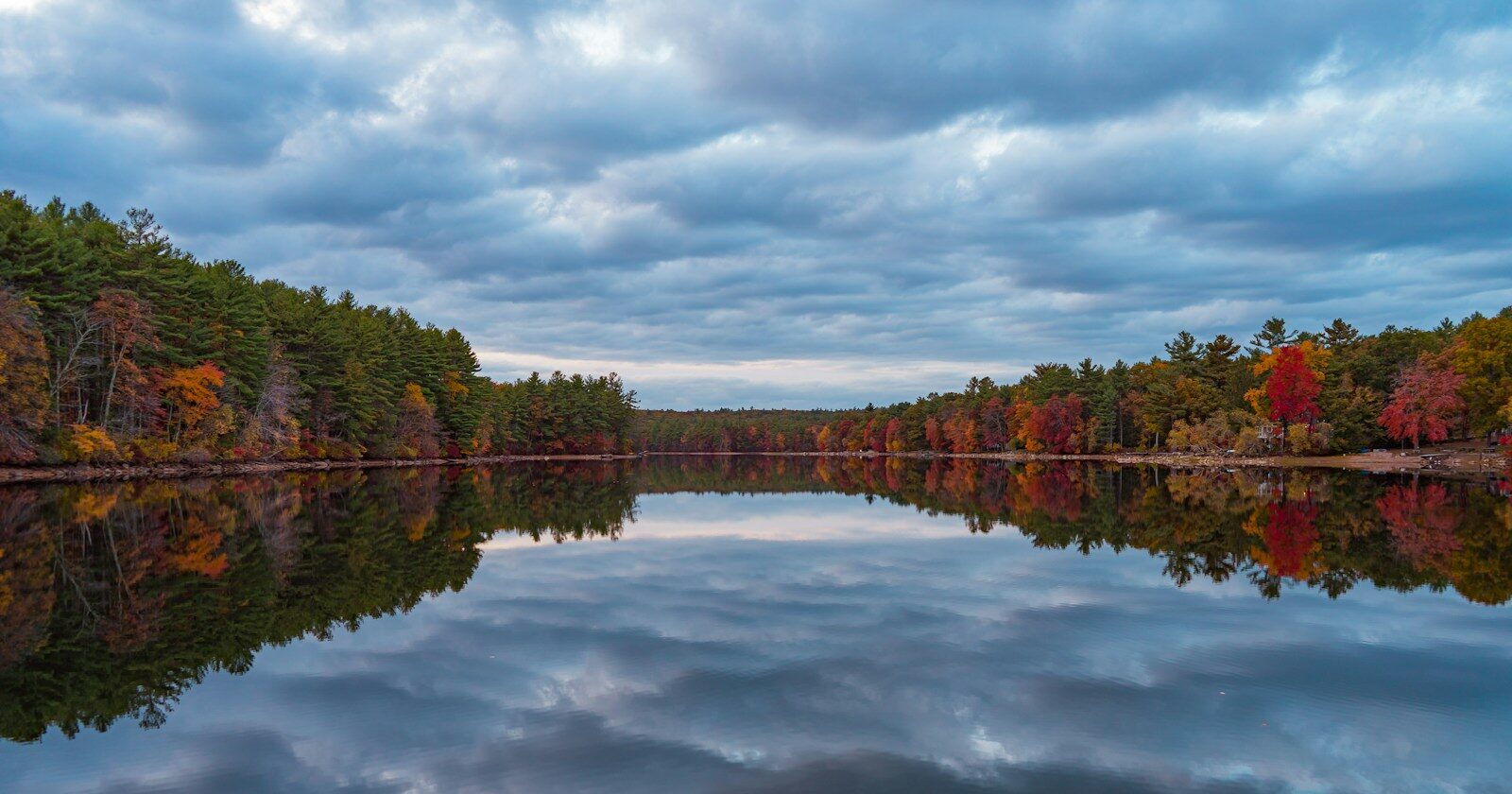 New England Travel Guide green trees beside river under cloudy sky during daytime