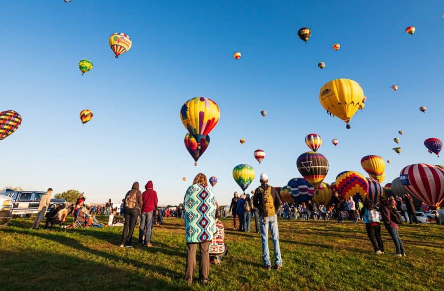 New Mexico Travel Guide hot air balloons on green grass field under blue sky during daytime