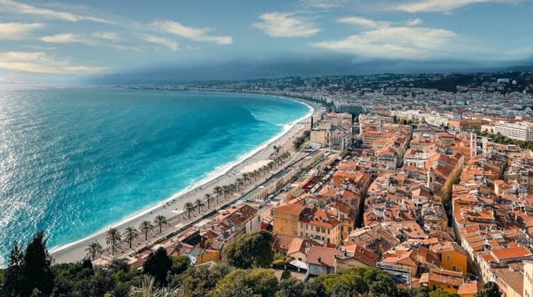 Nice Travel Guide an aerial view of a city next to the ocean