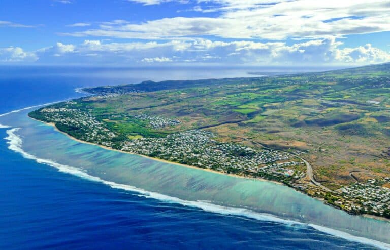 Réunion Island Travel Guide aerial view of green and brown field beside body of water during daytime