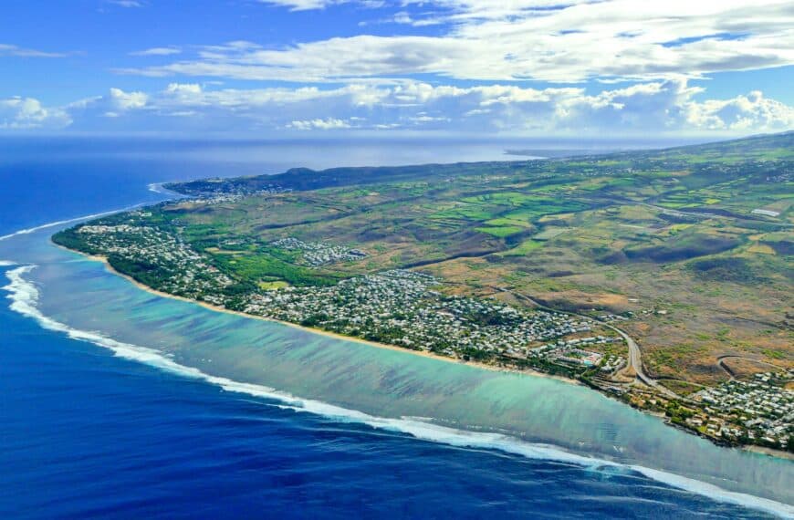 Réunion Island Travel Guide aerial view of green and brown field beside body of water during daytime