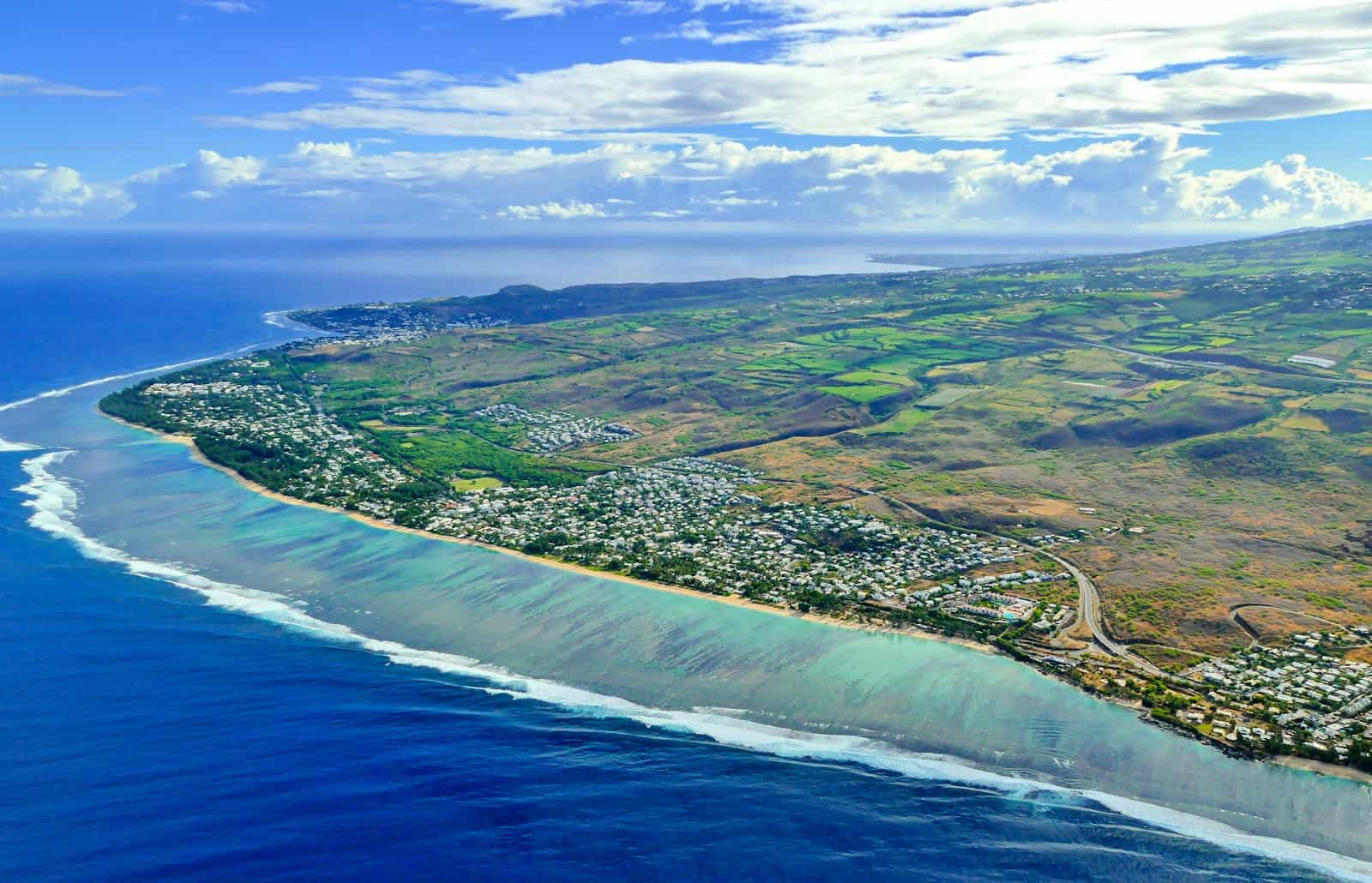Réunion Island Travel Guide aerial view of green and brown field beside body of water during daytime