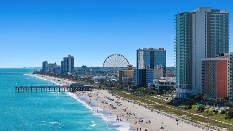 myrtle beach travel guide A view of a beach with a ferris wheel in the distance