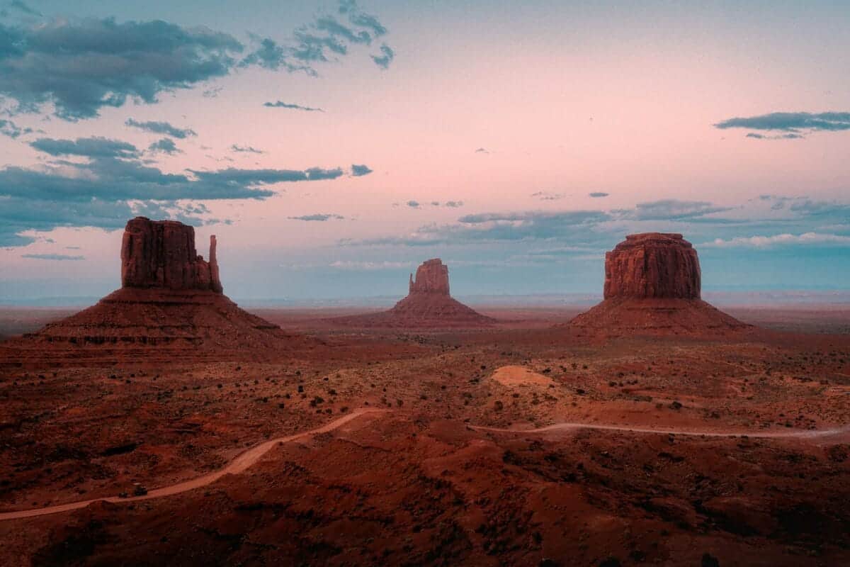 Explore North America A desert landscape with mountains and a dirt road