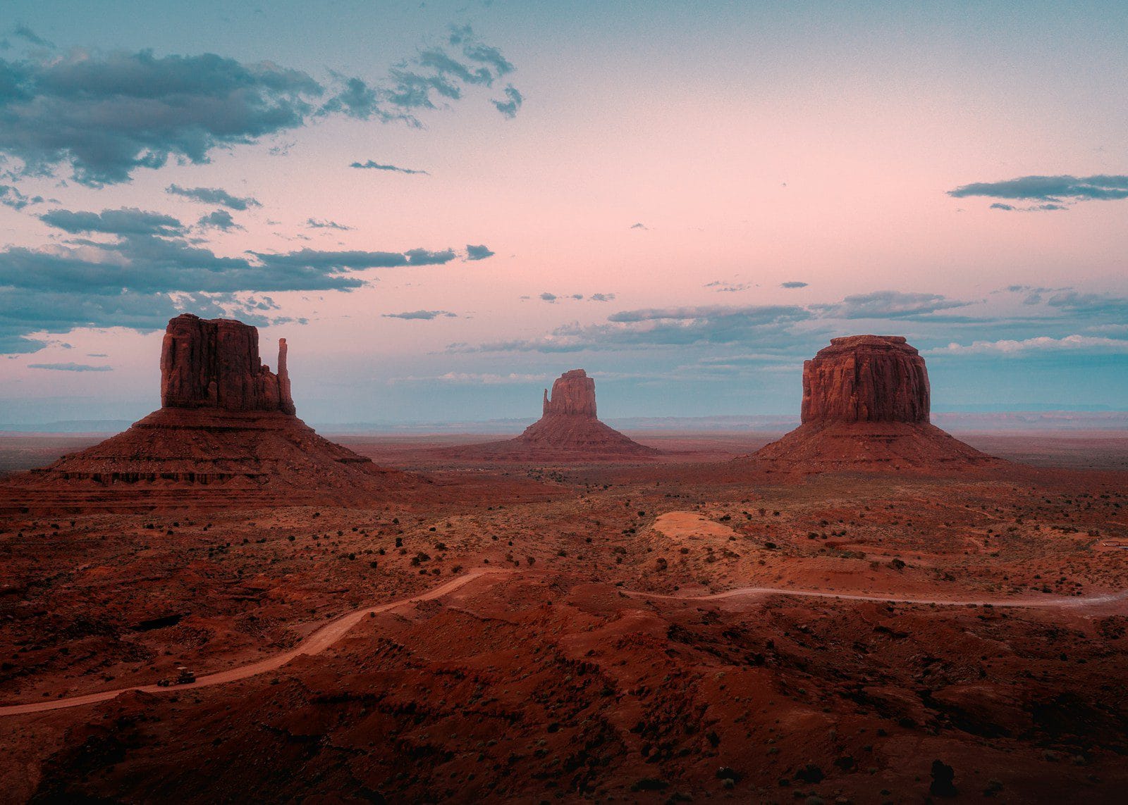 Explore North America A desert landscape with mountains and a dirt road
