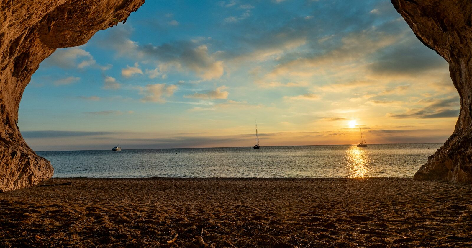 Sardinia Tours the sun is setting in a cave on the beach