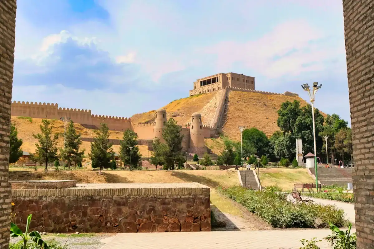 Tajikistan Travel Guide a view of a castle through two brick walls