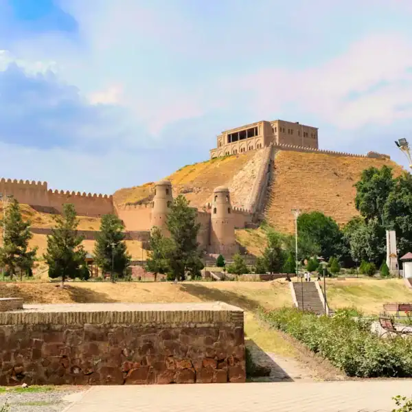 Tajikistan Travel Guide a view of a castle through two brick walls