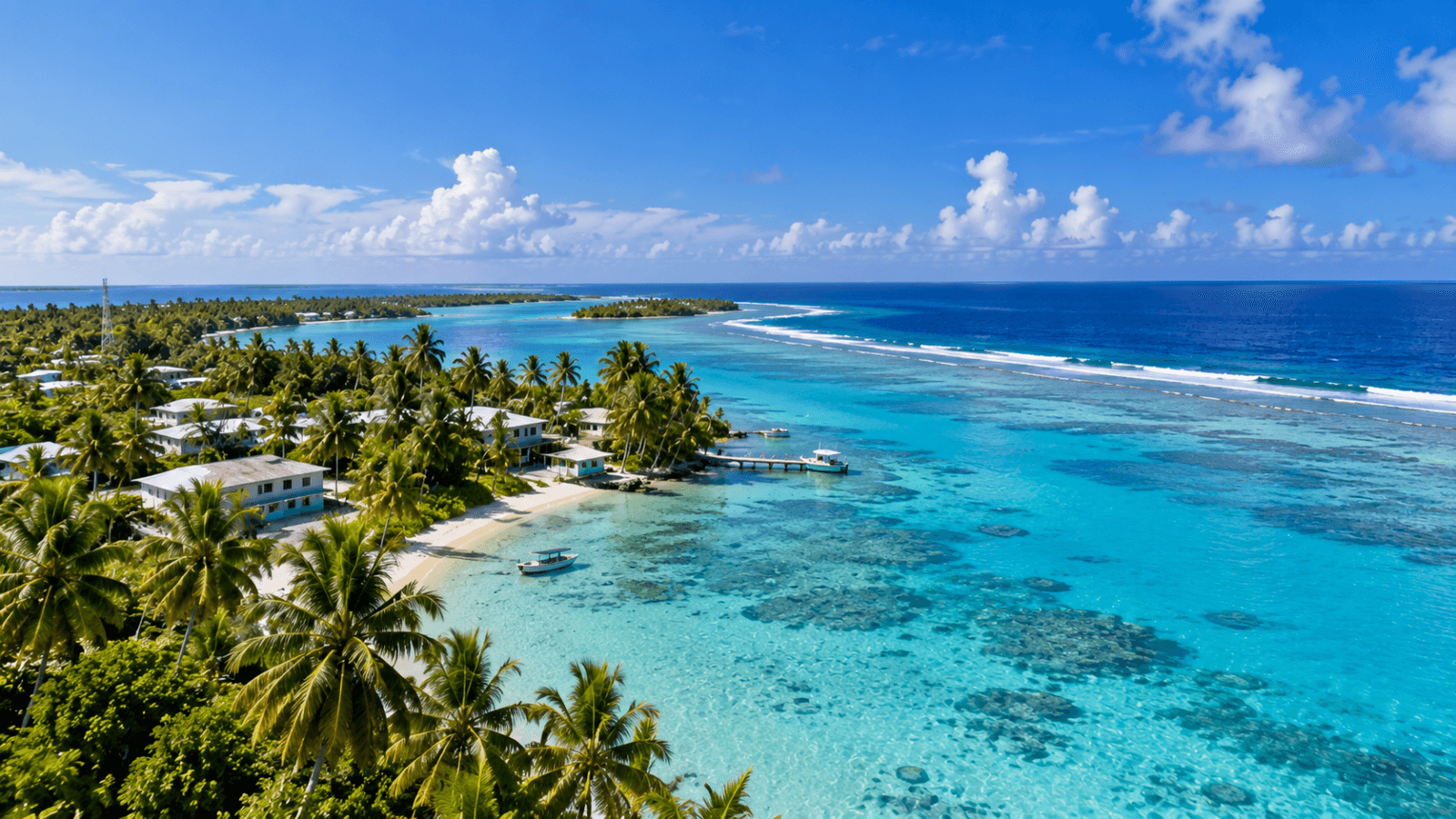 Aerial view of a Marshall Islands atoll with palm-lined shores, turquoise lagoon water, coral reefs, boats, and open Pacific Ocean.