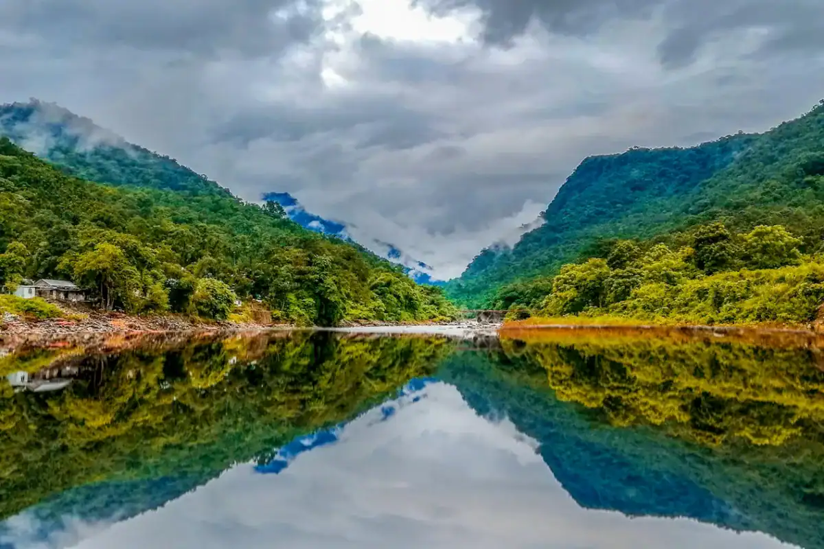 Bangladesh travel guide green mountain beside body of water under cloudy sky during daytime