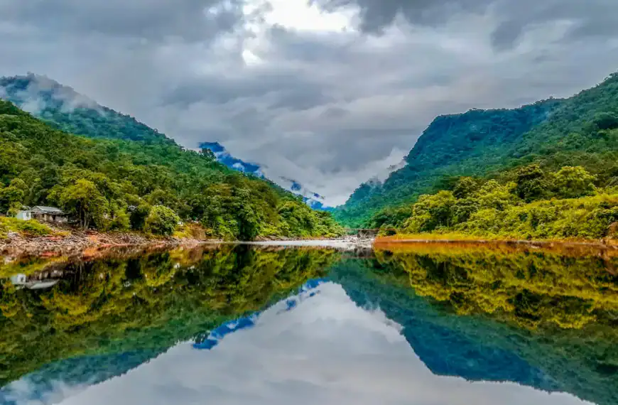 Bangladesh travel guide green mountain beside body of water under cloudy sky during daytime