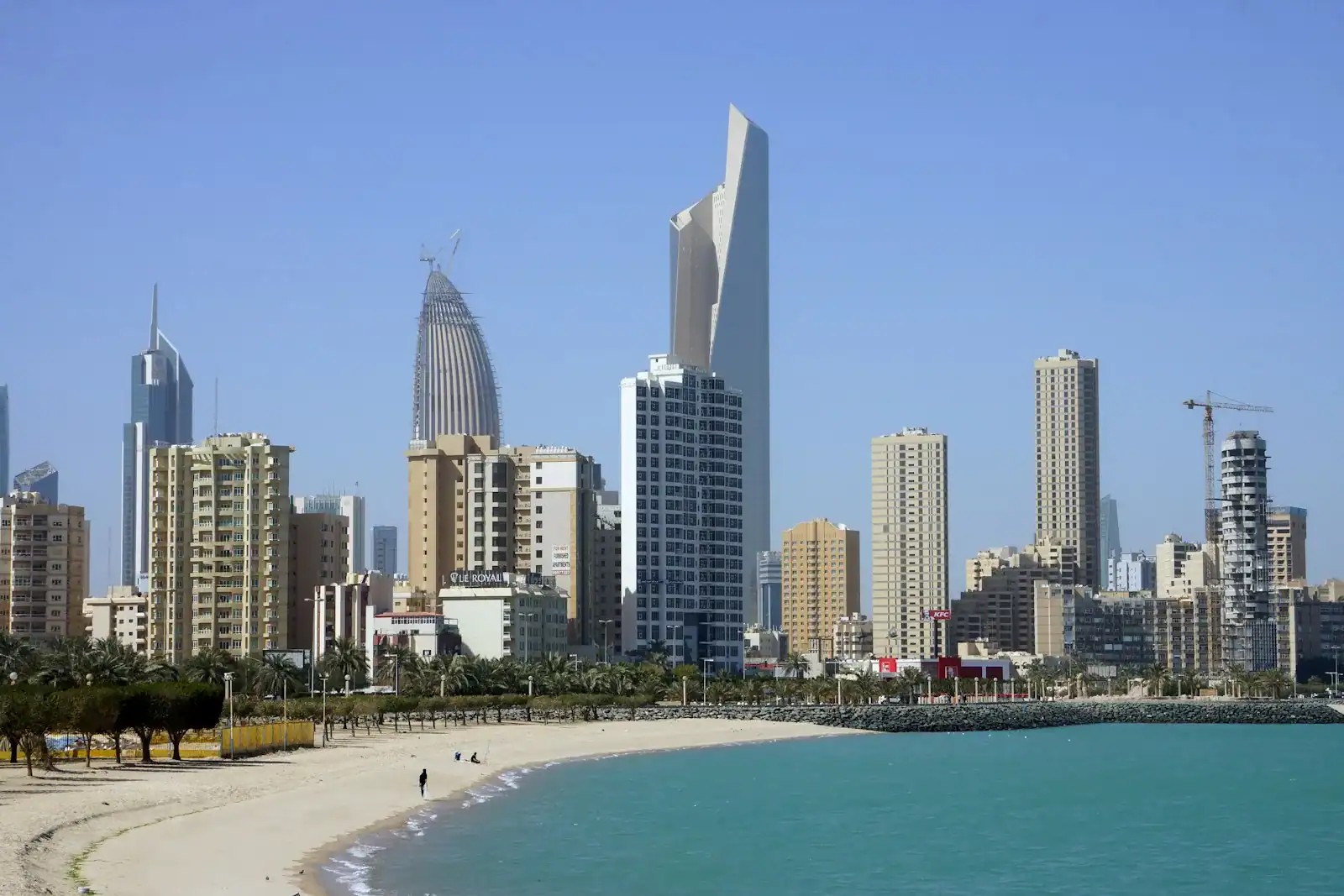 Kuwait Travel Guide people on beach near high rise buildings during daytime