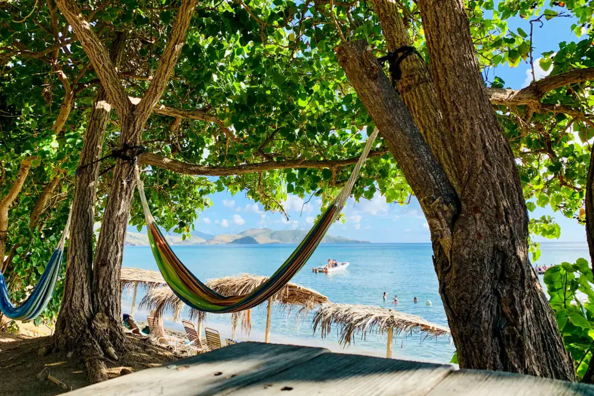 St Kitts and Nevis travel guide a hammock hanging between two trees on a beach