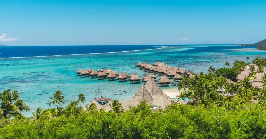 moorea travel guide A tropical beach with thatched huts and blue water