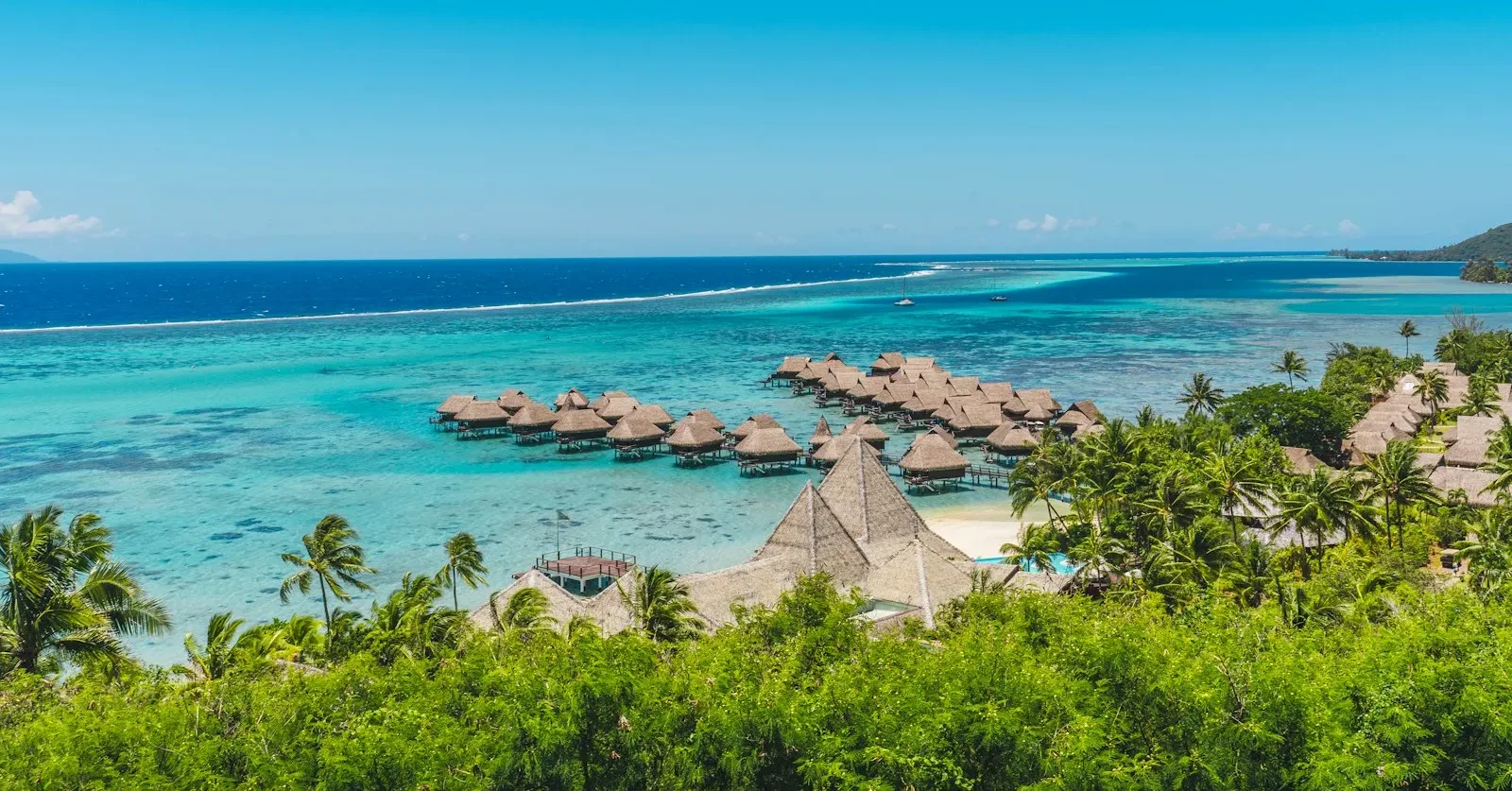 moorea travel guide A tropical beach with thatched huts and blue water