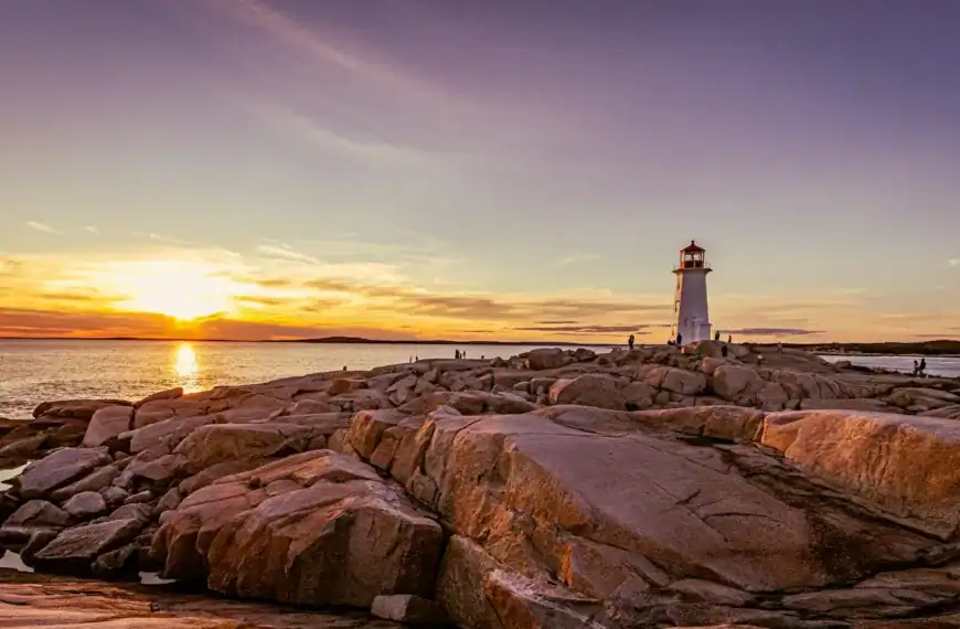 Nova Scotia Travel Guide a lighthouse sitting on top of a rocky shore