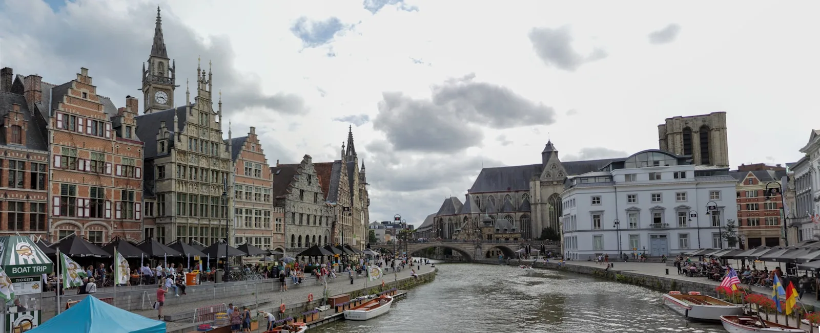 Ghent Travel Guide a river with boats and buildings along it