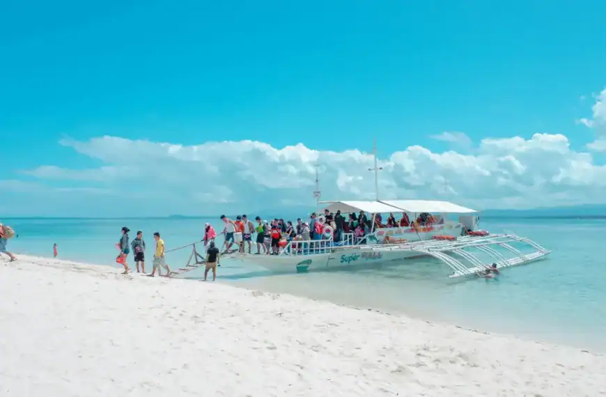 Philippines Travel Statistics people in white boat on seashore